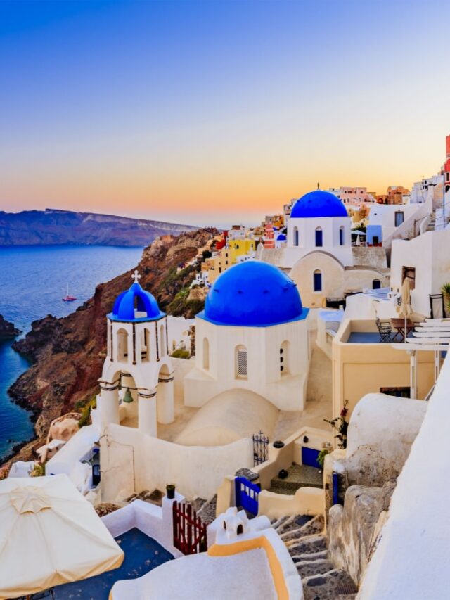 Amazing sunset view with white houses in Oia village on Santorini island in Greece.