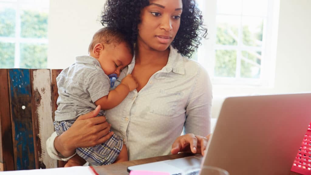 Mother With Baby Working In Office At Home