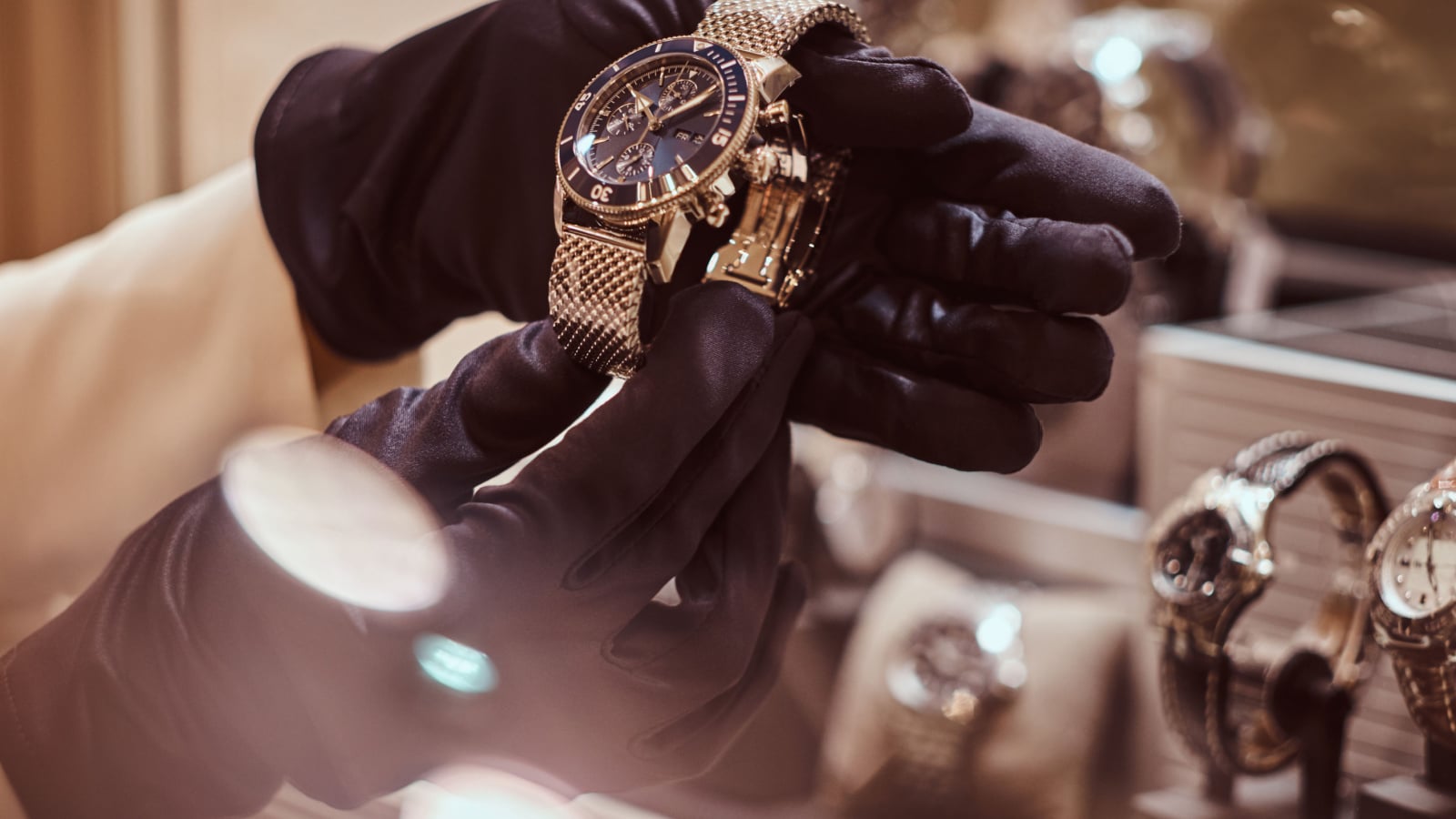 Close-up of the seller's hands in gloves shows the exclusive men's watch from the new collection in the luxury jewelry store