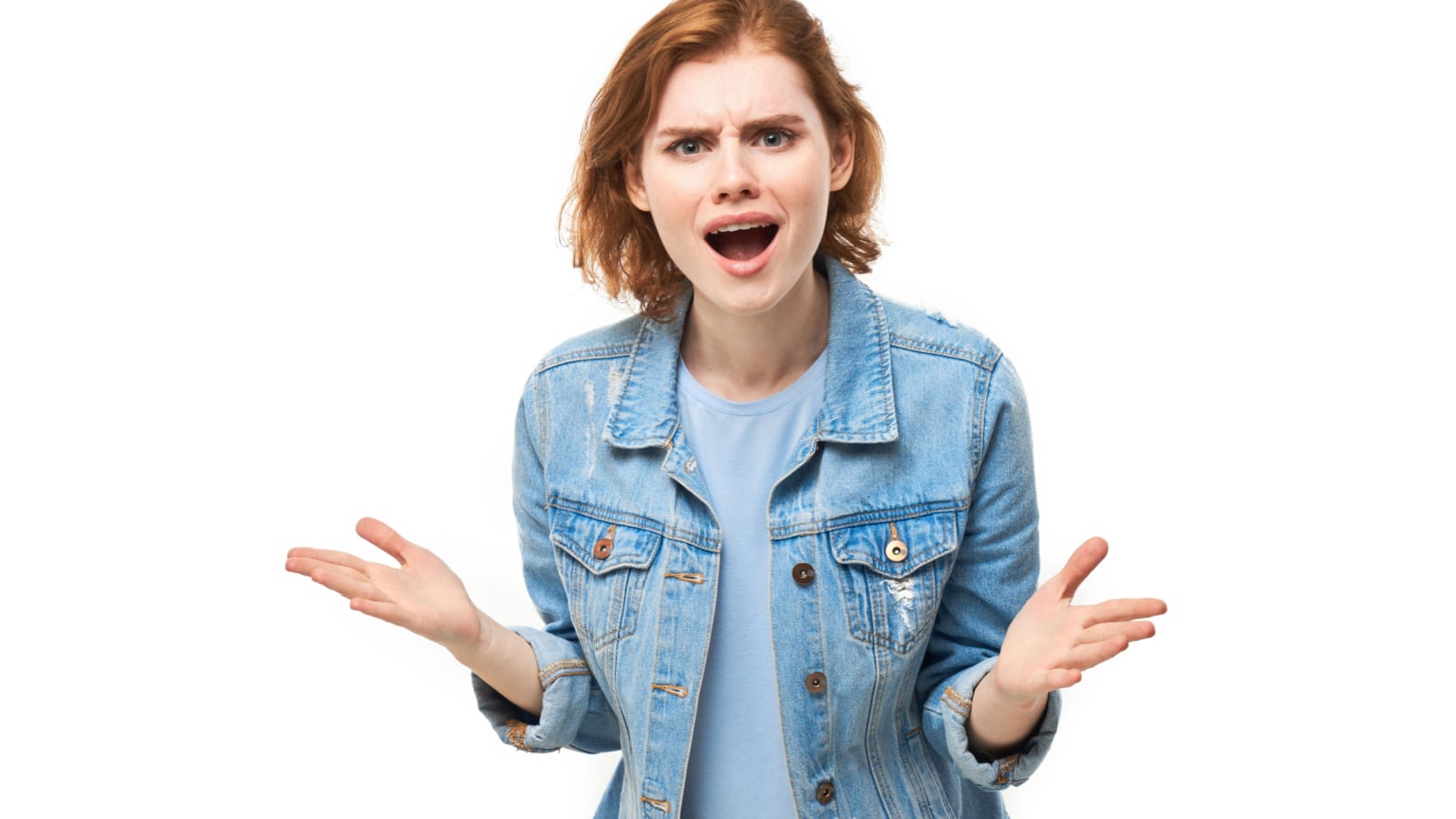 Portrait of angry young woman screaming splashes hands on white studio background. Devil face. Human emotions, facial expression concept