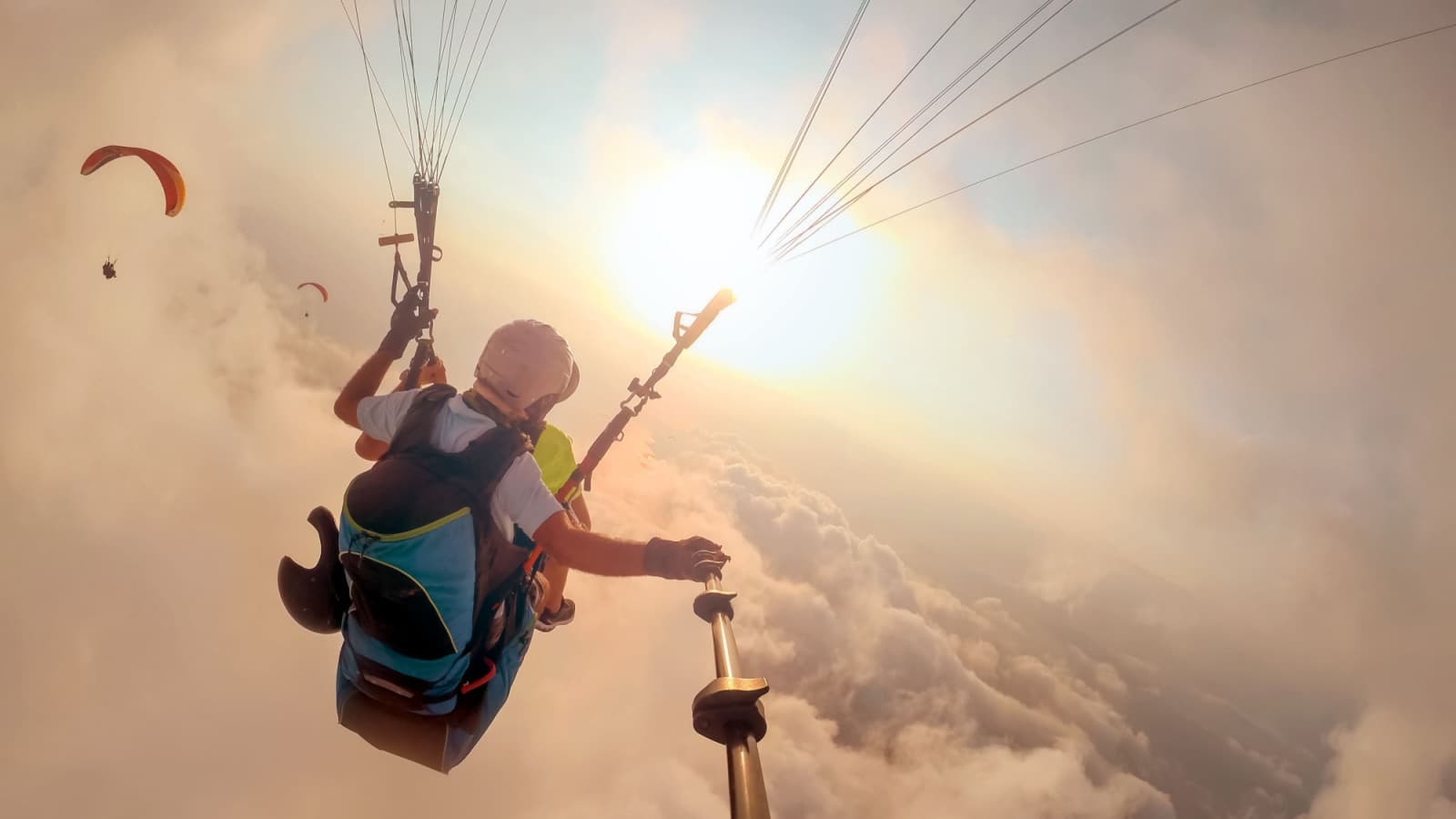 Paragliding in the sky. Paraglider tandem flying over the sea with blue water and mountains in bright sunny day. Aerial view of paraglider and Blue Lagoon in Oludeniz, Turkey. Extreme sport. Landscape