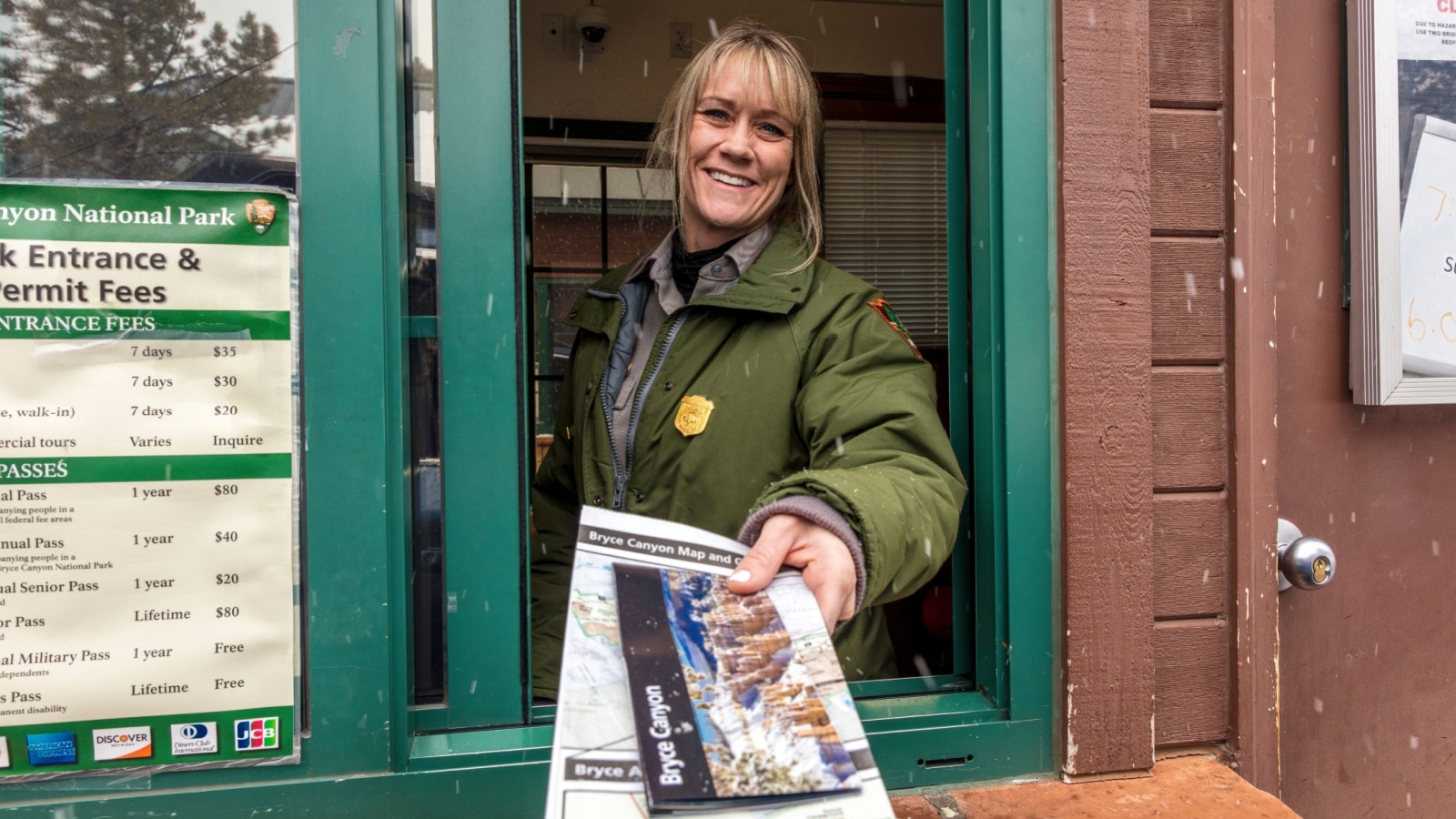 FEB 14, BRYCE NAT PARK, UTAH, USA - Female blond National Park Ranger hands out brochure through window at Bryce National Park, Utah