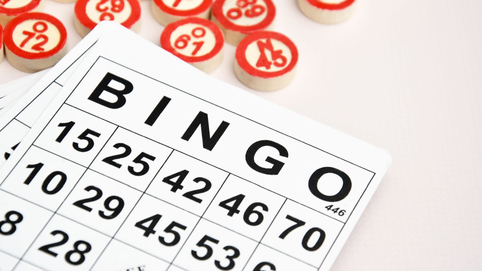 Many wooden chips with numbers and cards for a board game of bingo or lotto on a light background. Russian Lotto has similar rules to the classic worldwide bingo game.