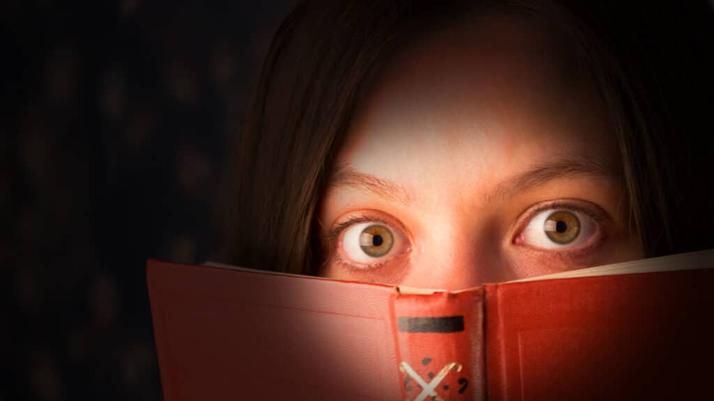 scared girl with a book, reading horrors