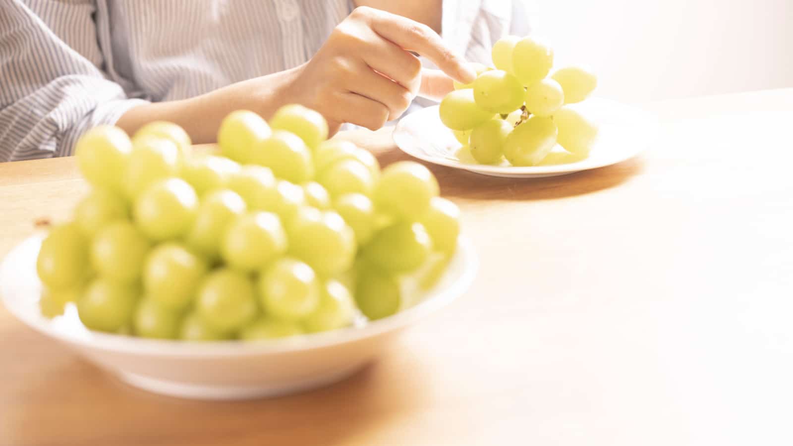 Woman eating grapes (Shine Muscat)