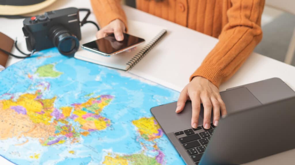 Travel planning, vacation, holiday trip concept, asian young tourist woman hand take note, check list using laptop searching information booking ticket or hotel online, preparation for journey trip.