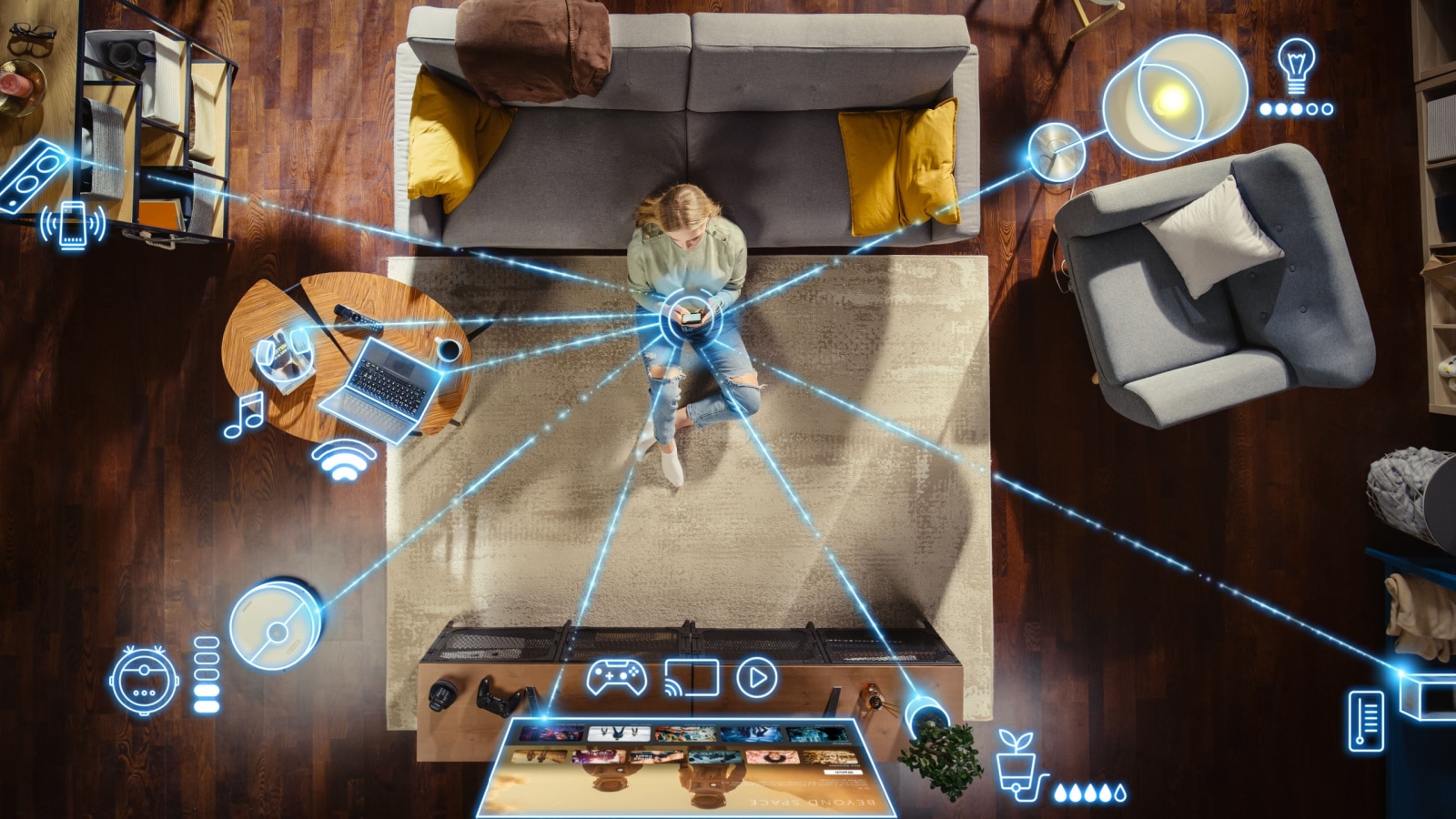 Top View Of Caucasian Woman In the Loft Apartment Sitting On Carpet Next To Couch and Connecting Smartphone to Smart Home System. VFX Edit Visualizing Connected Devices. Laptop, TV, Speaker.