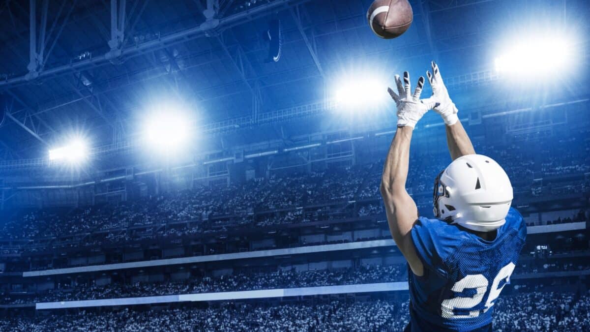 American Football Player Catching a touchdown Pass in a large stadium.