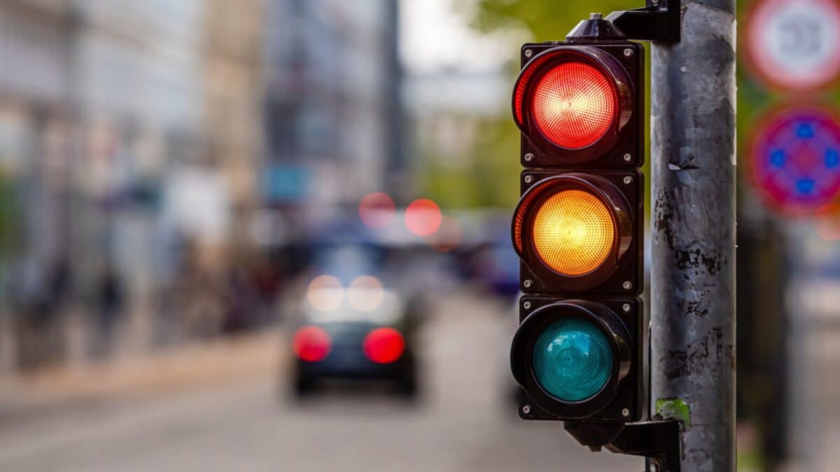 a city crossing with a semaphore, red and orange light in semaphore, traffic control and regulation concept