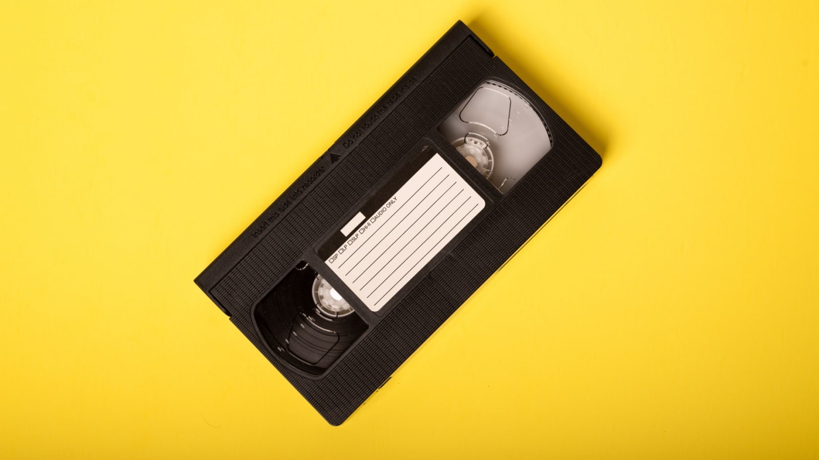 Movie Night - Video Tape on Yellow Background. VHS Tape, a staple of an age before streaming, when movie rental stores were a necessary element of watching a movie at home.