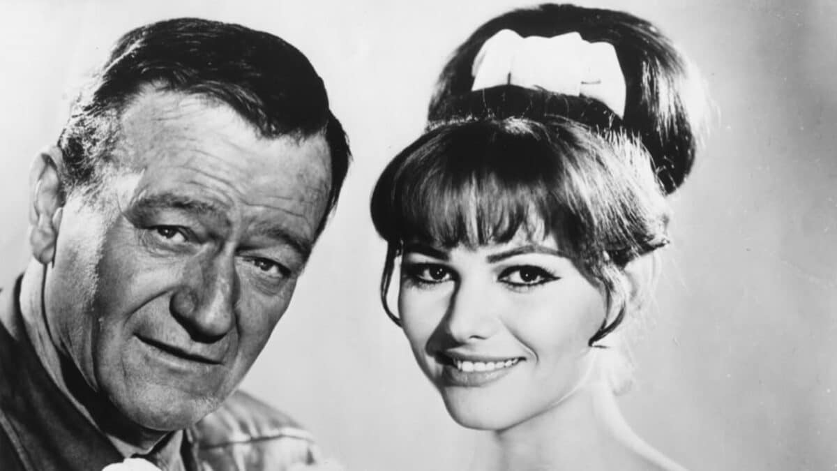 John Wayne and co-star smiling. 