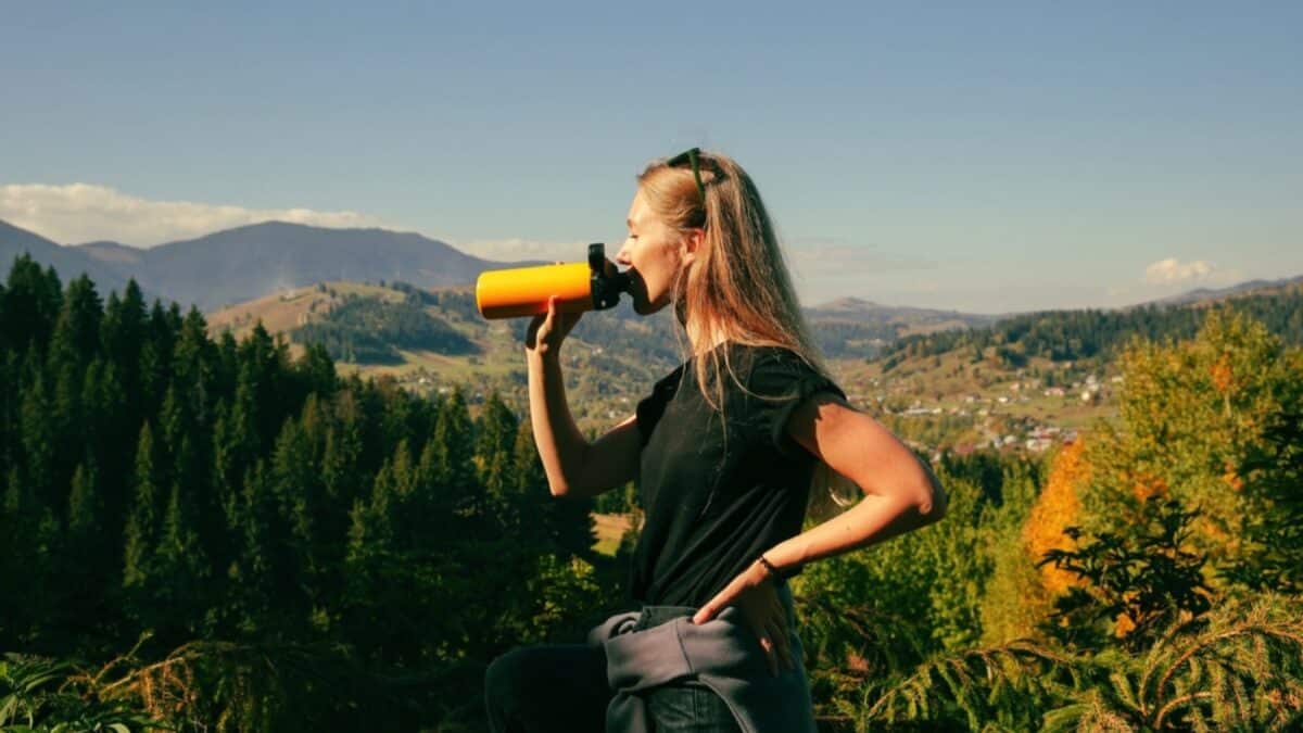 Traveler drinking water from reusable bottle