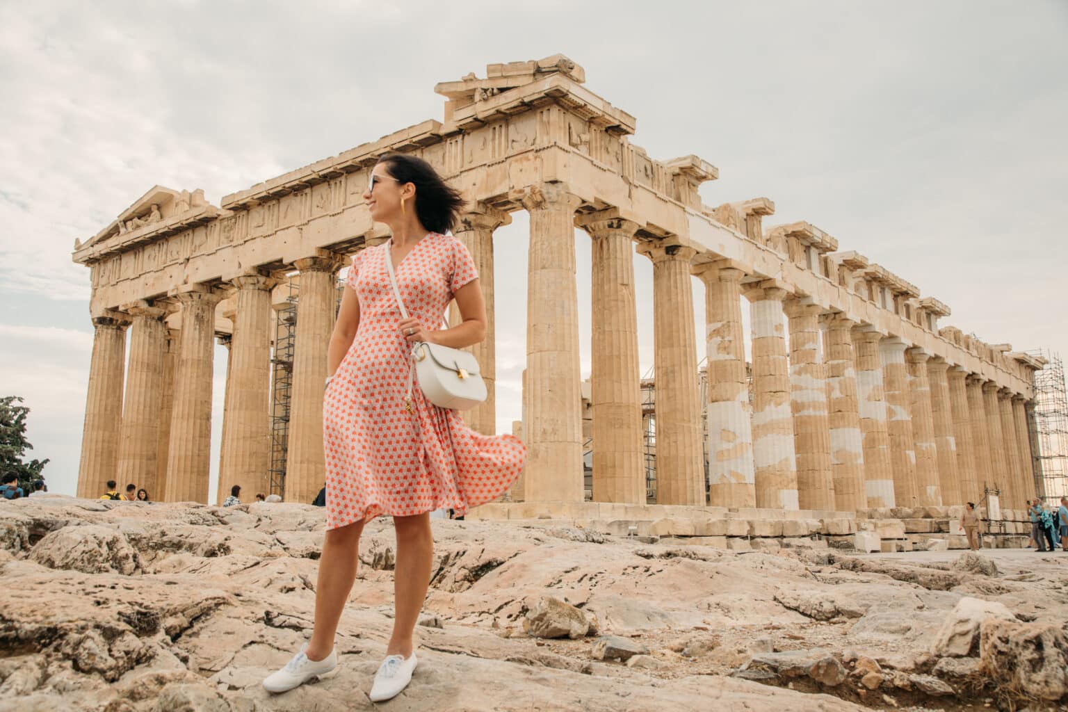 Lindsey of Have Clothes, Will Travel wearing a Karina Dress standing in front of the Acropolis in Athens, Greece on a cloudy and windy day