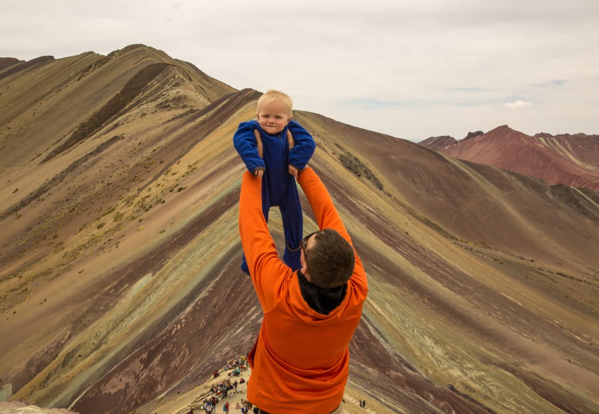 Colson being held up like the Lion King at Rainbow Mountain