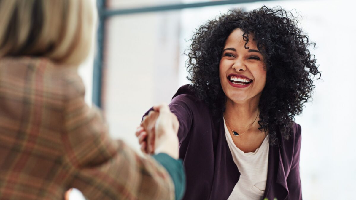 Handshake with a happy, confident and excited business woman or human resources manager and a female colleague, partner or employee. An agreement, deal or meeting with a coworker in the boardroom