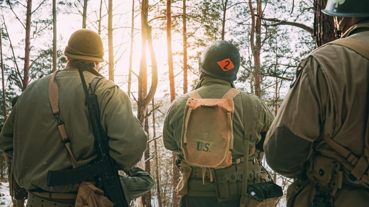 Back View On Re-enactors Dressed As American Infantry Soldier Watch For Bright Sun At Winter Day. Group Of Usa Soldiers Armed Of Sturmgewehr 44 Or Assault Rifle 44. Usa Army Soldiers Of World War Ii.