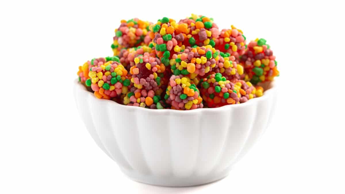 A Sweet and Tangy Candy with Small Candies on the Outside of a Chewy Center on a White Background