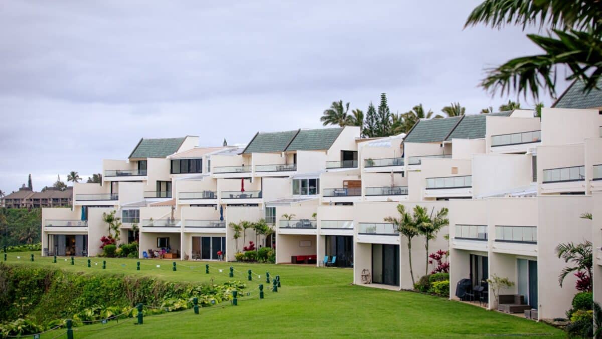 Vacation condo rental building in Princeville, with balconies facing the ocean, surrounded by palms and manicured lawa, north shore of Kauai, Hawaii