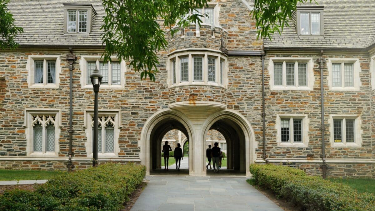 Students walk under gothic arches on the campus of Duke University in Durham NC