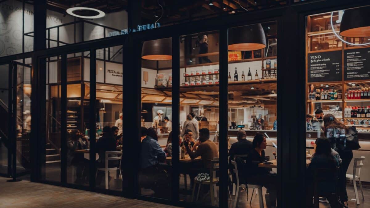 London, UK - September 03, 2021: View from outside of people sitting inside Eataly, a 42,000 square Italian food market in Broadgate that includes restaurants, cookery school and market.