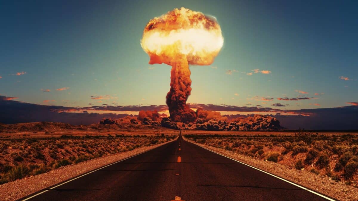 Asphalt road goes to a nuclear explosion. Terrible atomic explosion of a nuclear bomb with a mushroom cloud of radioactive dust. Hydrogen bomb test.