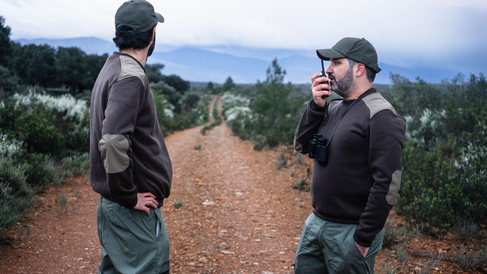 Team of Park Rangers with uniform using Walkie Talkie radio to monitor wildlife in the nature reserve