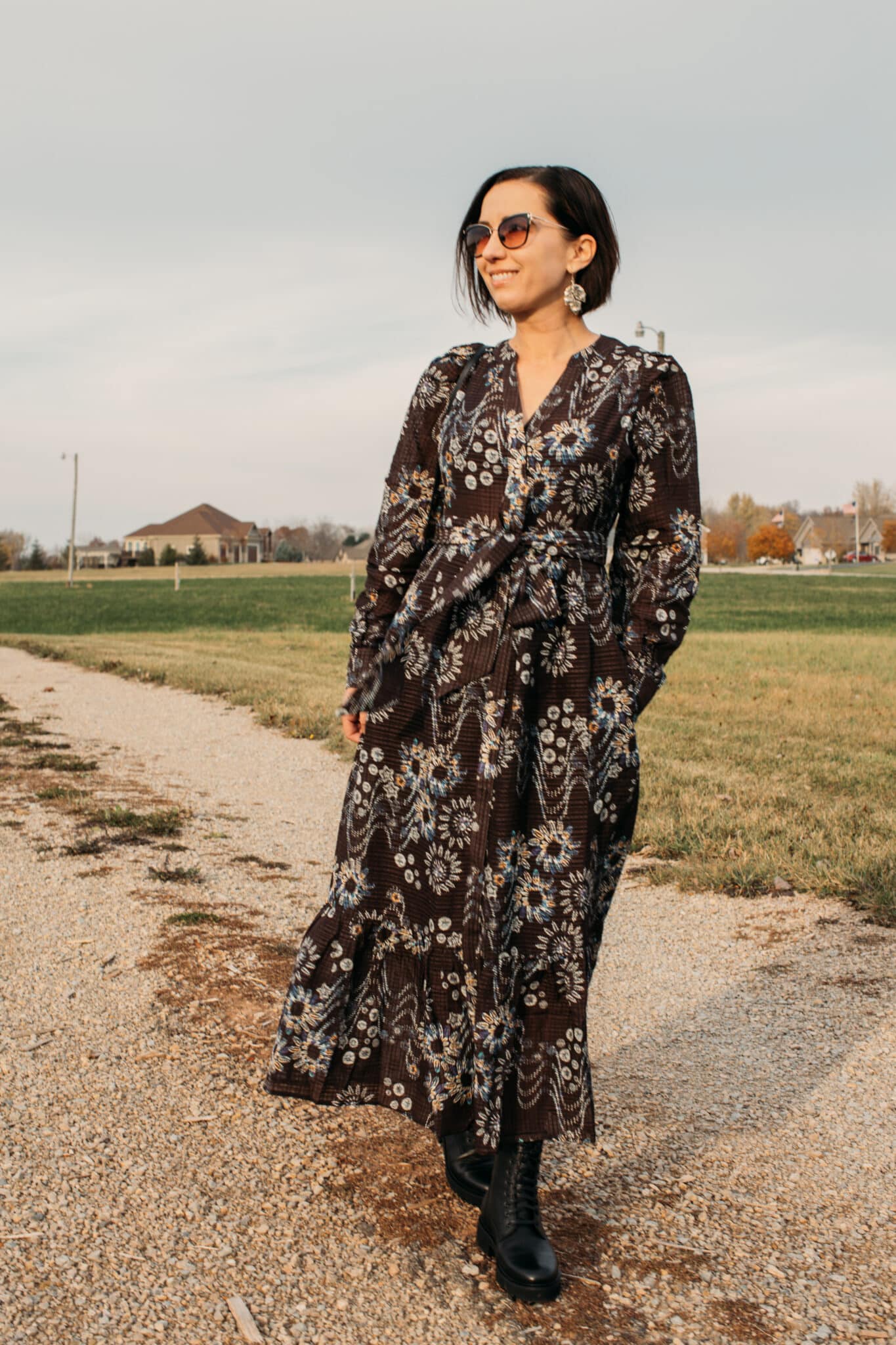 Lindsey with her hands in her pockets wear a Marie Oliver dress