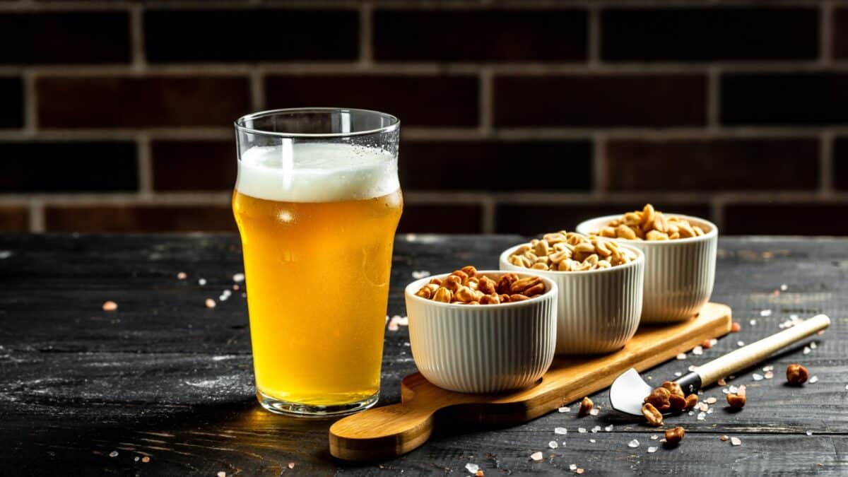 Bowl of nuts and beer on wooden table, set of peanuts with different flavors, Snacks for beer. banner, menu, recipe,