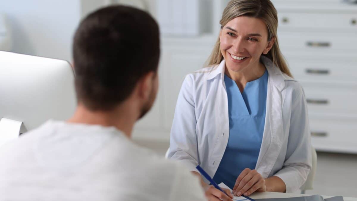 Professional doctor working with patient at white table in hospital