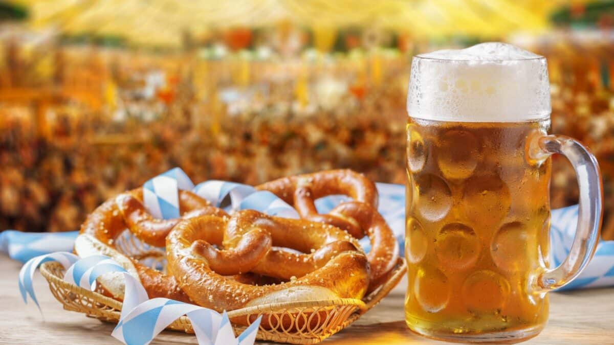 Cold mug of beer and basket of pretzels on tent beer background. Oktoberfest, beer festival