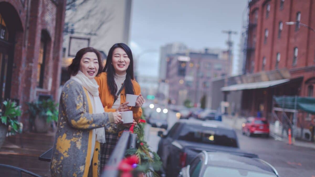 Happy asian elderly mother and adult daughter enjoying coffee at Portland pearl district outdoor cafe